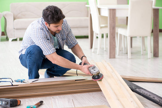 man laying flooring at home